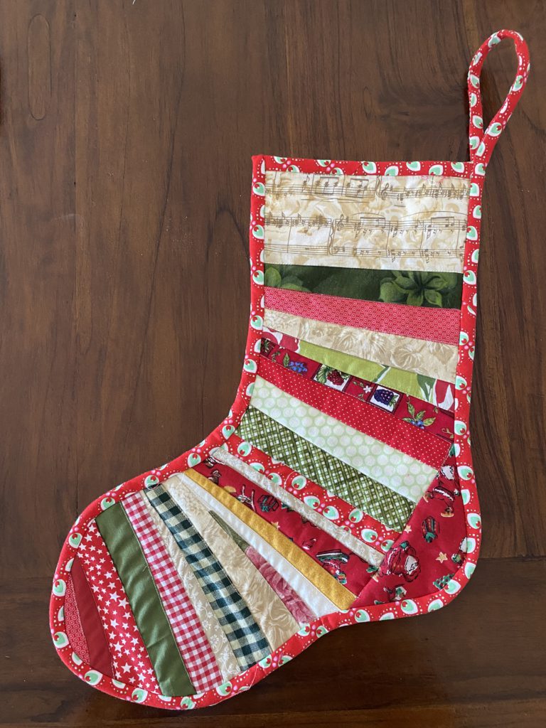 "Quilted Christmas Scrappy String Stockings” is a Free Christmas Quilted Stocking Pattern designed by Susie Stuklis from Susie's Scraps!